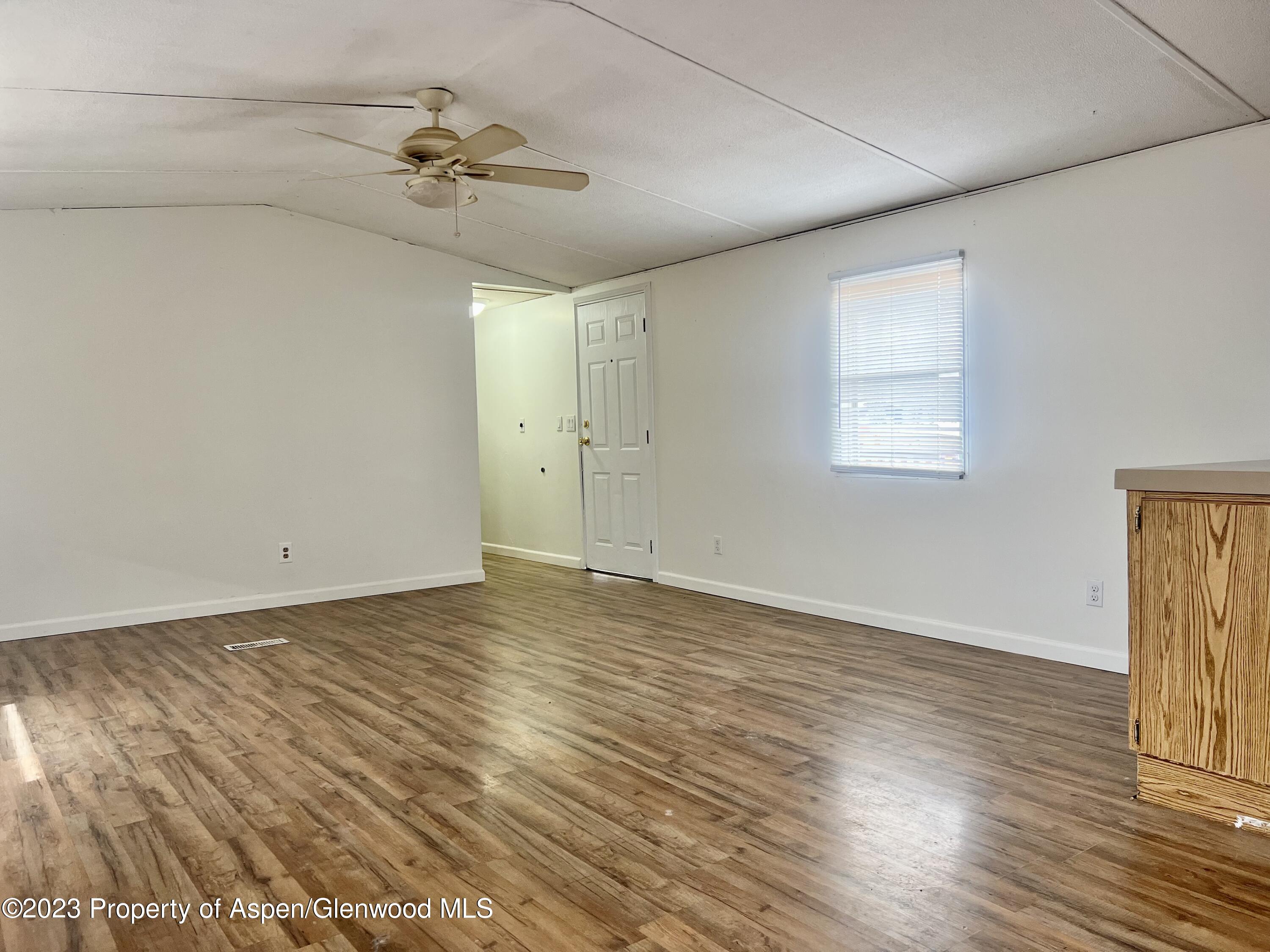 346 Greig Avenue De Beque, CO 81630 - Photo 7 of 15 a view of a room with wooden floor and a ceiling fan