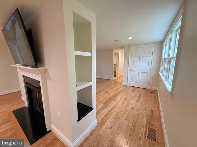 a view of empty room with wooden floor