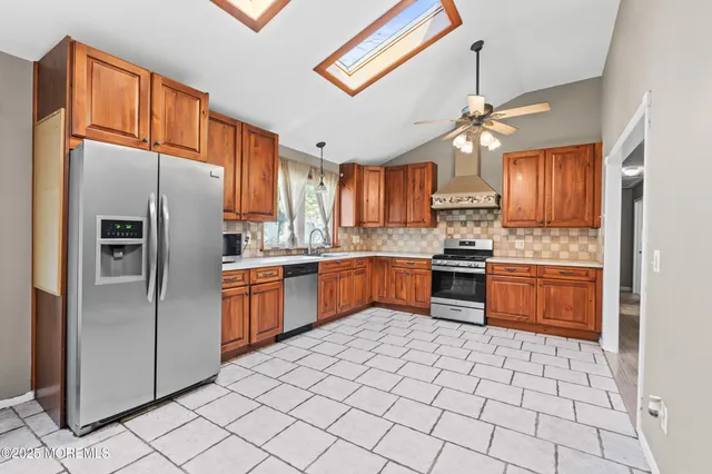 a kitchen with stainless steel appliances granite countertop a refrigerator and a stove top oven