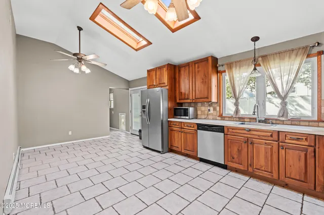 a kitchen with stainless steel appliances granite countertop a refrigerator and a sink
