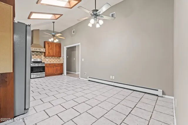 a view of an empty room and a kitchen
