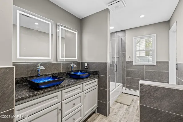 a bathroom with a granite countertop sink a toilet and shower