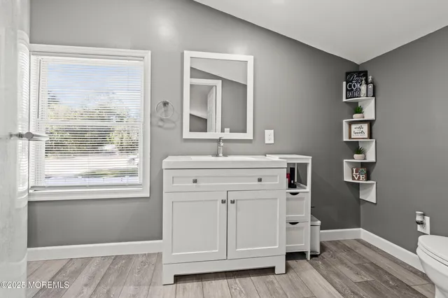 a bathroom with a sink a mirror and a window