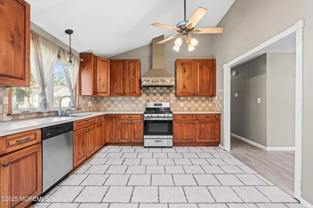 a kitchen with stainless steel appliances granite countertop a stove a sink and a refrigerator