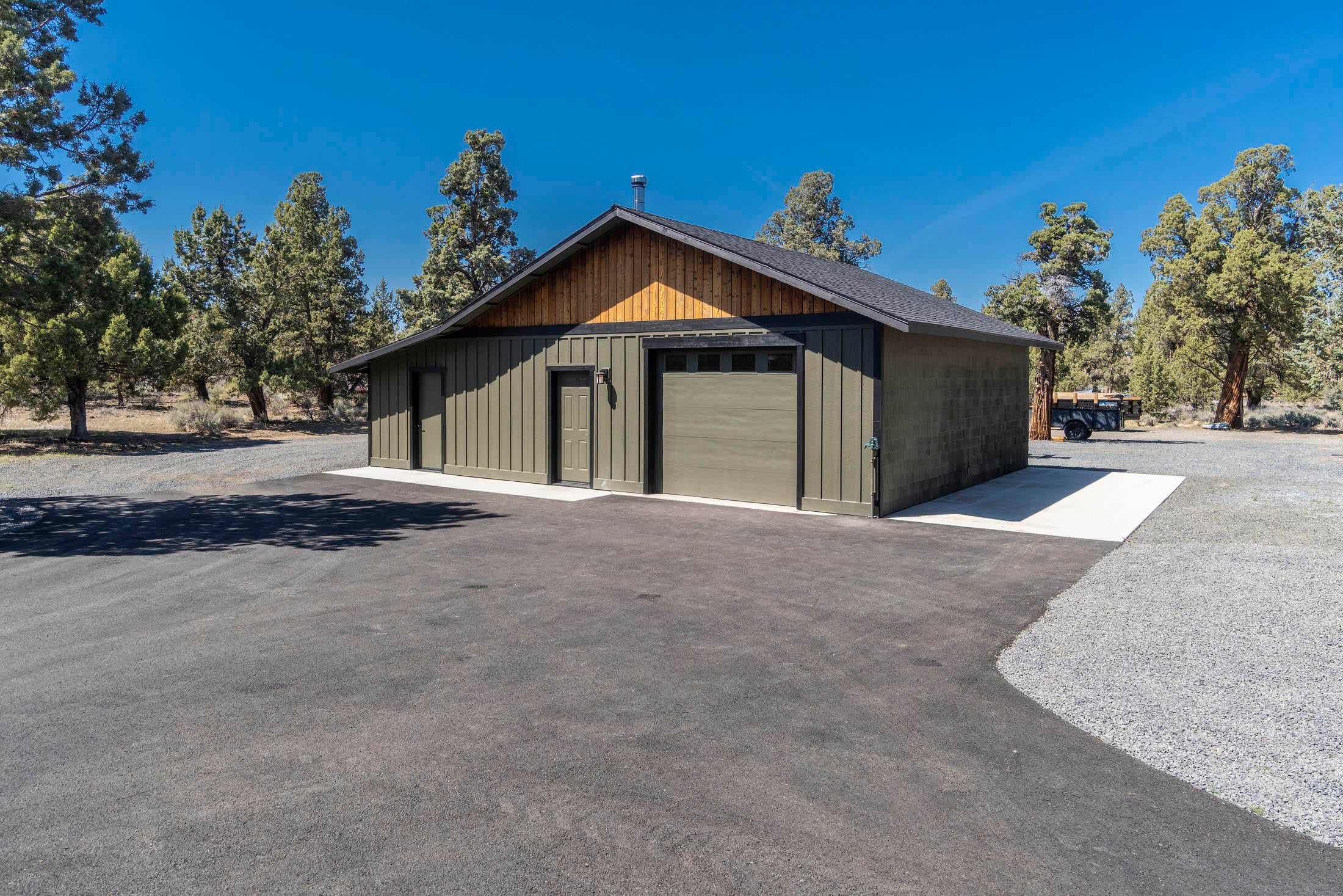 64486 McGrath Road Bend, OR 97701 - Photo 27 of 38 28' x 28' shop with new paint in 2020. 10' x 28' concrete pad for RV parking, firewood storage area, and huge gravel area behind shop for storage.
