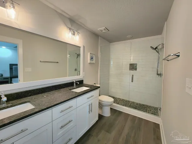 a spacious bathroom with a granite countertop sink mirror vanity and toilet