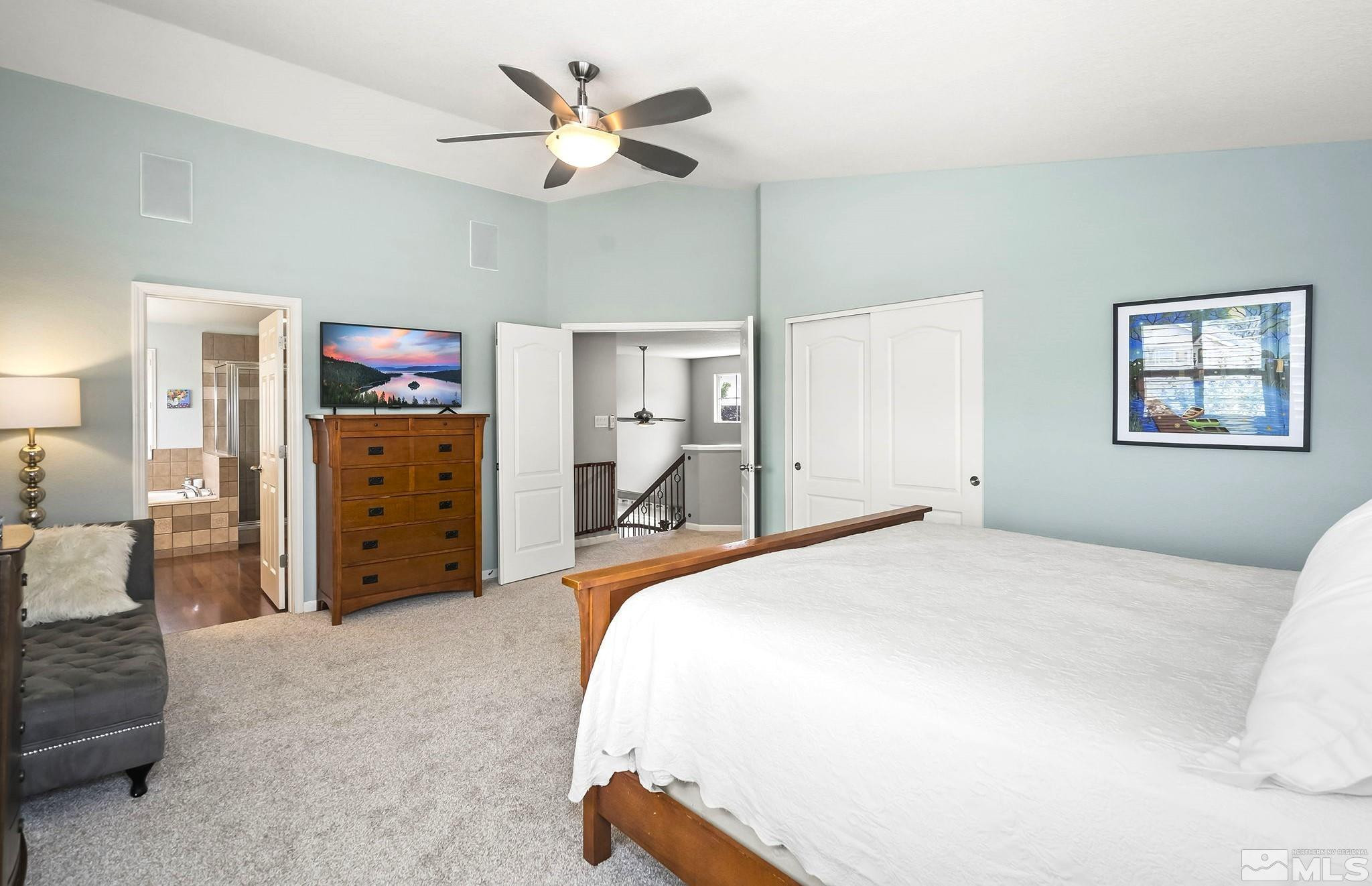 10031 Cascade Falls Drive Reno, NV 89521 - Photo 14 of 30 a spacious bedroom with a bed and a chandelier