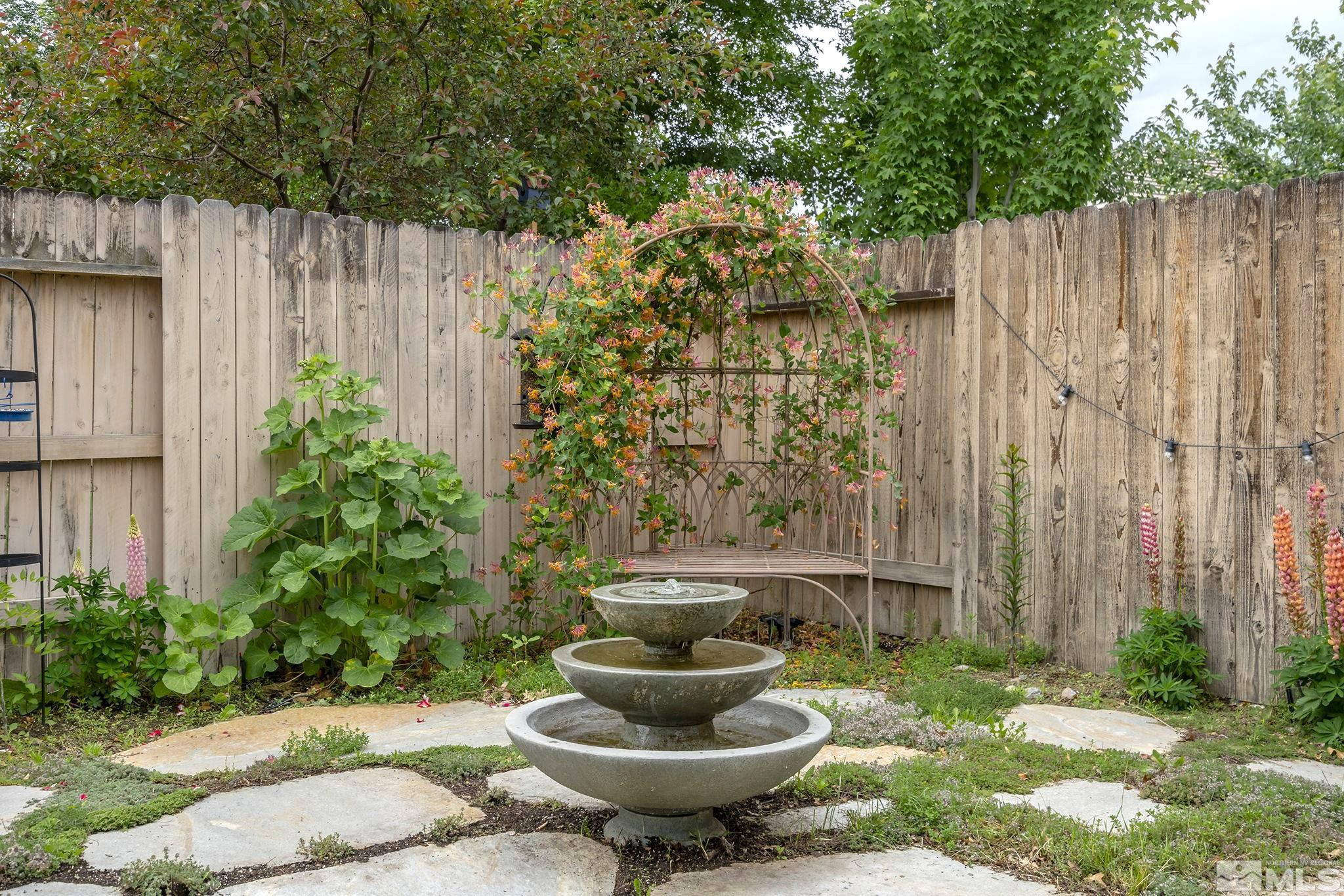 10031 Cascade Falls Drive Reno, NV 89521 - Photo 25 of 30 a view of a backyard with table and chairs potted plants and wooden fence