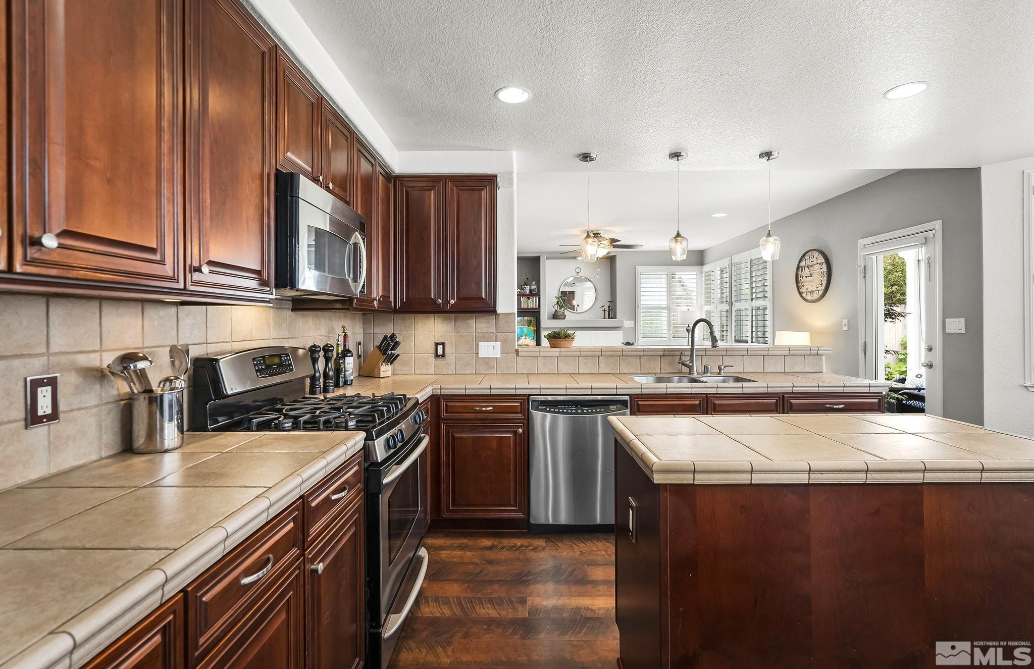 10031 Cascade Falls Drive Reno, NV 89521 - Photo 6 of 30 a kitchen with stainless steel appliances granite countertop a sink stove and cabinets