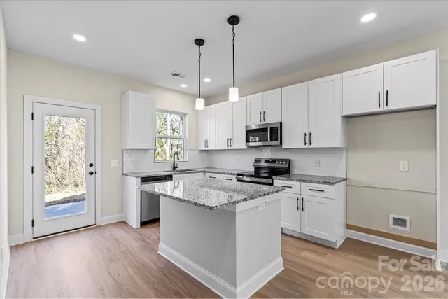 a kitchen with granite countertop a sink stove and cabinets