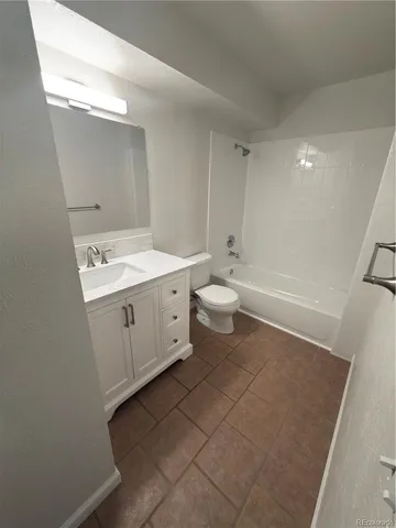 a spacious bathroom with a sink a toilet and a mirror