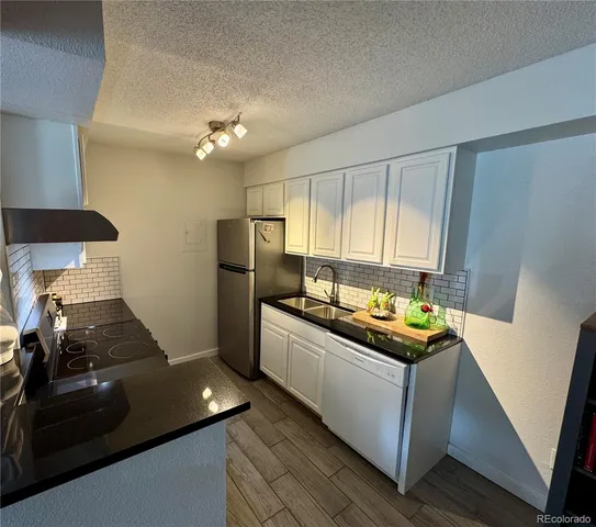 a kitchen with stainless steel appliances a sink stove and refrigerator