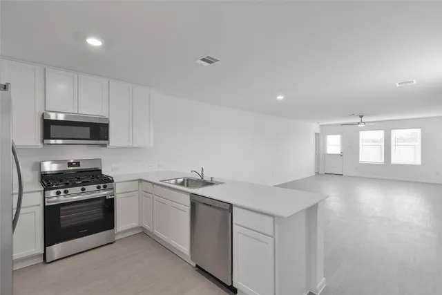 a kitchen with granite countertop a sink stainless steel appliances and cabinets