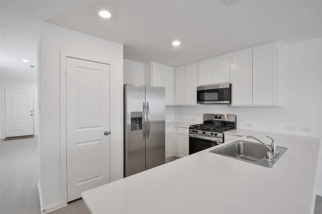 a kitchen with a refrigerator a stove top oven a sink and dishwasher