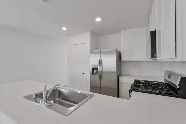 a kitchen with stainless steel appliances granite countertop a refrigerator and a sink