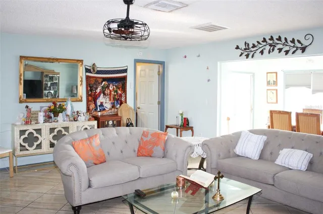 a living room with furniture kitchen view and a window