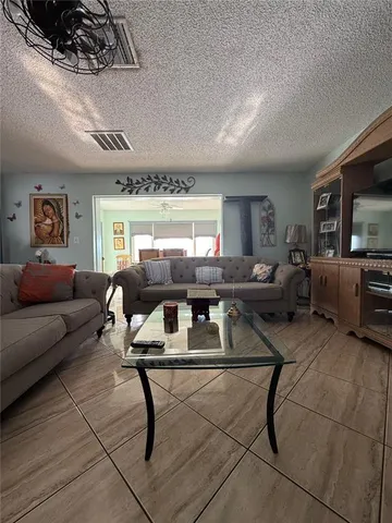 a living room with furniture a large window and a table