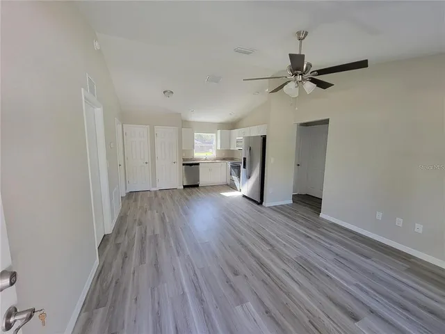 a view of empty room with wooden floor