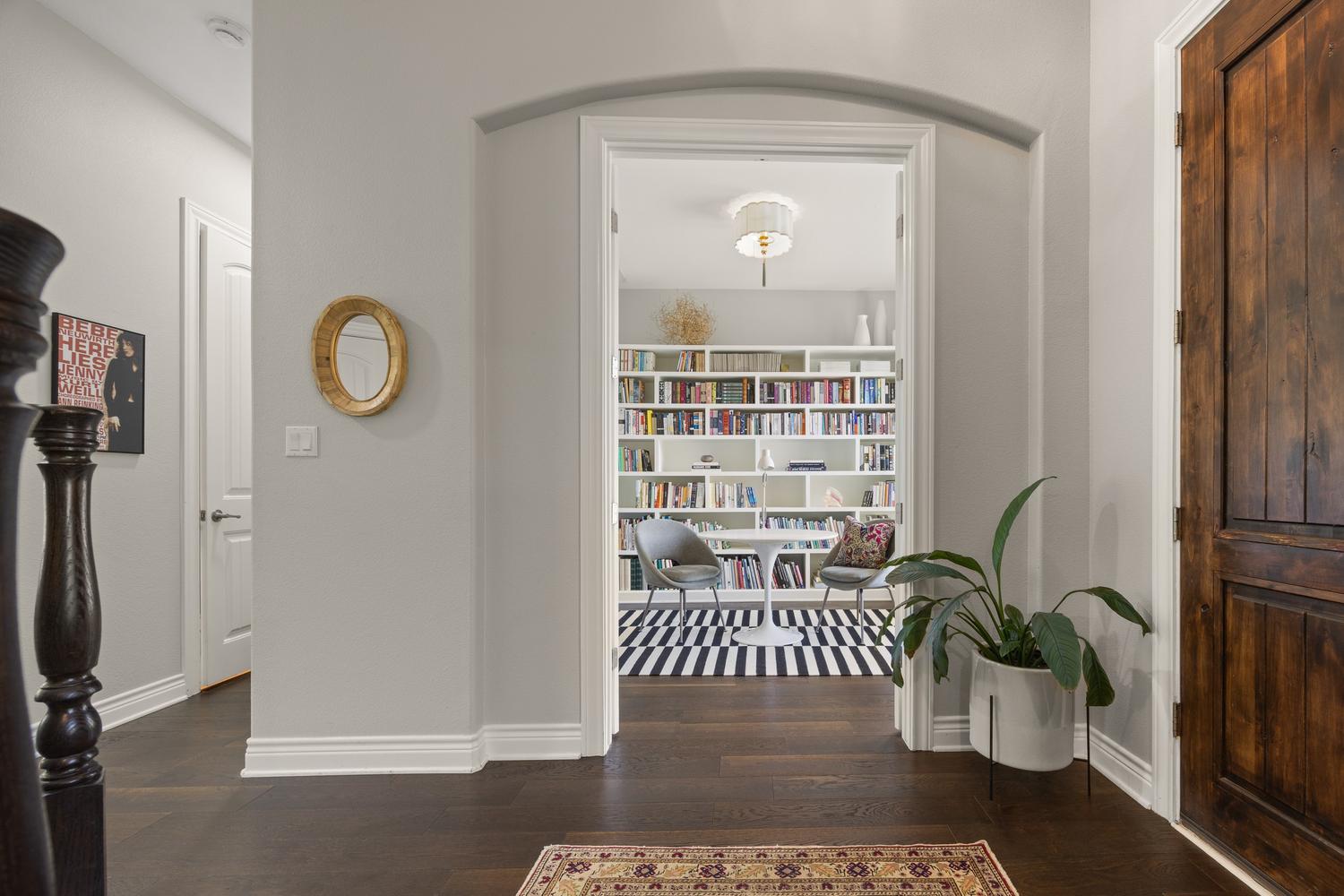 1135 Blue Ridge Drive Dripping Springs, TX 78620 - Photo 12 of 36 Elegant dark hardwood floors guide you into a study with extensive built-in shelving, perfect for a home office or library.