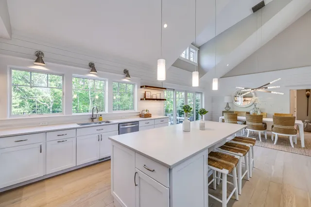 a kitchen with a stove a sink a dining table and chairs