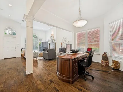 a view of a workspace with furniture and a large window