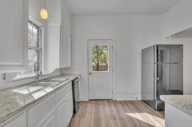 a kitchen with a sink cabinets and wooden floor