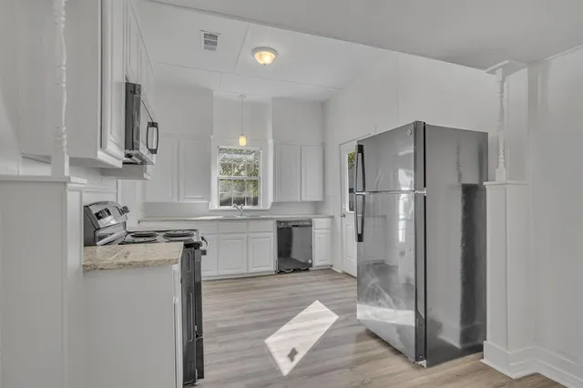 a kitchen with a refrigerator a sink and cabinets