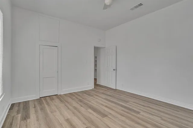 a view of an empty room with wooden floor