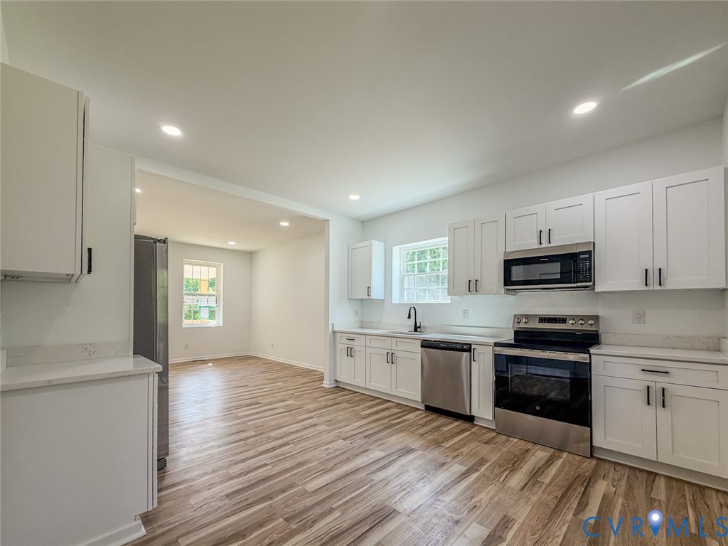 a kitchen with granite countertop a sink and steel appliances