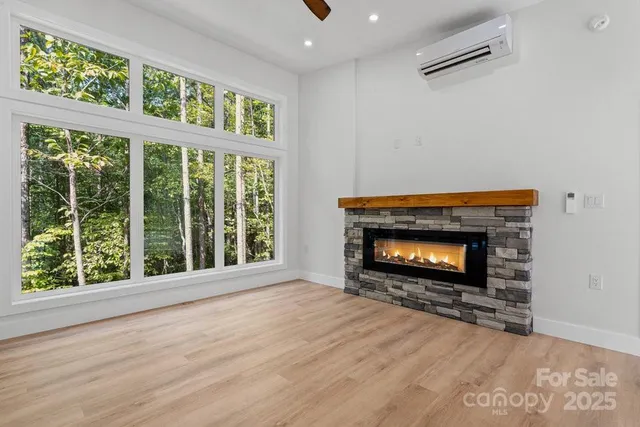 a view of an empty room with wooden floor and windows