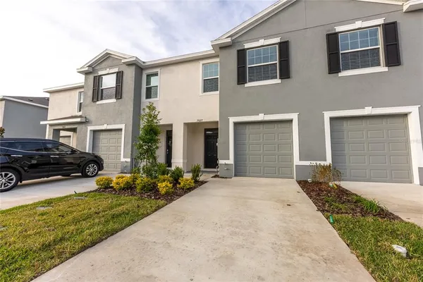a view of a house with a yard and a car parked beside it