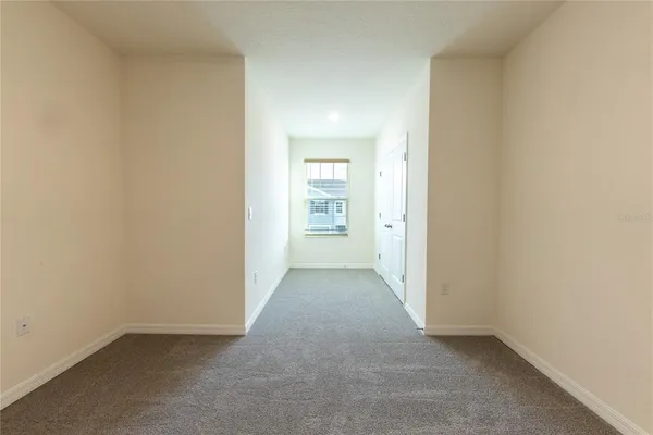 an empty room with closet and windows