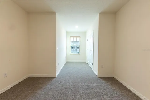 an empty room with closet and windows