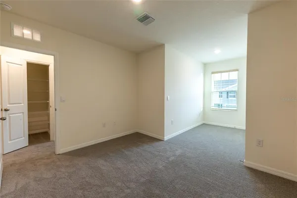 an empty room with closet and sliding door