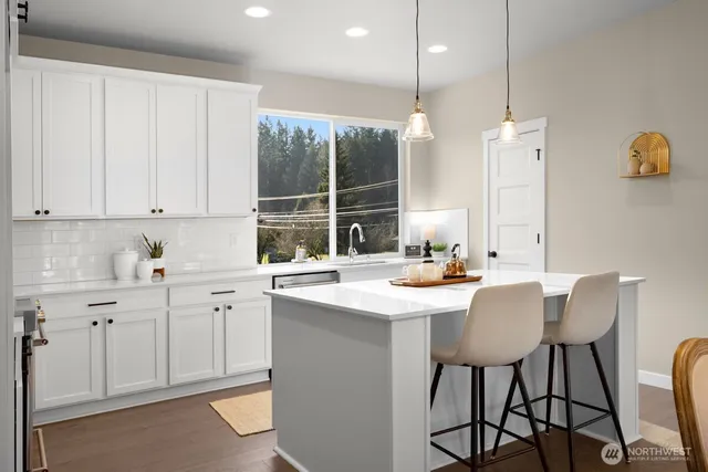 a kitchen with stainless steel appliances a sink a stove a table and chairs