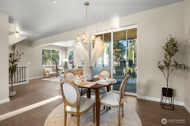 a dining room with furniture large windows and a chandelier