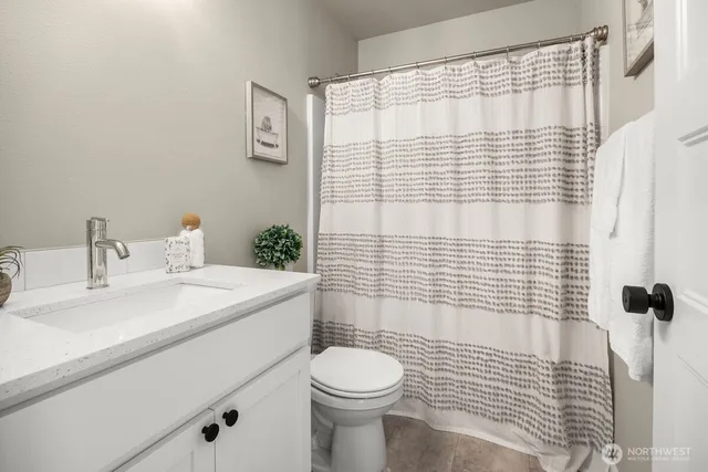 a bathroom with a sink a toilet and shower curtain