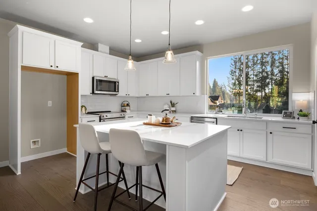 a kitchen with kitchen island granite countertop a sink a center island stainless steel appliances and cabinets