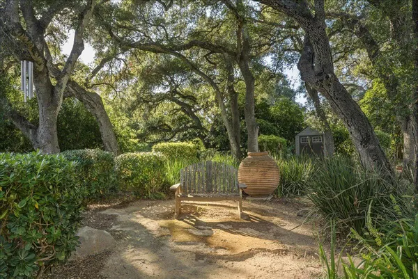 a backyard of a house with table and chairs under an umbrella