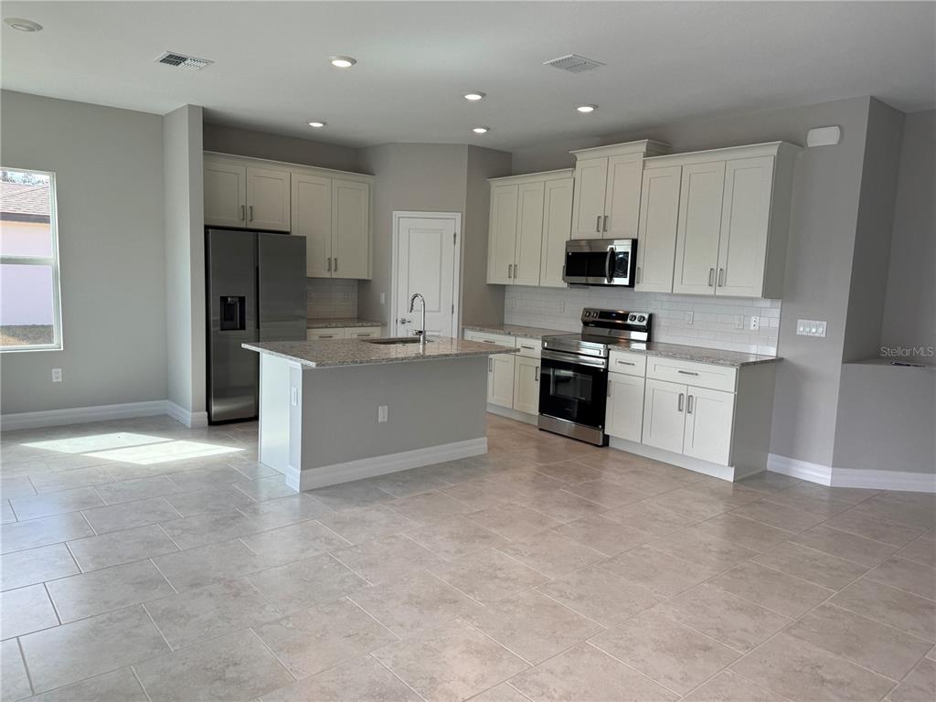 2268 Brewster Road North Port, FL 34288 - Photo 7 of 33 a kitchen with a stove a sink and a refrigerator