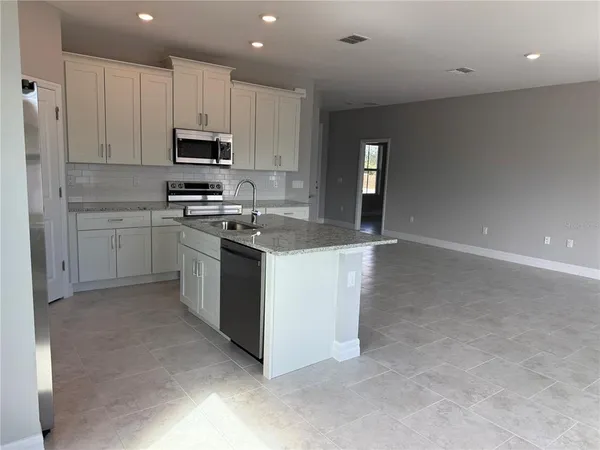 a kitchen with stainless steel appliances granite countertop a stove a sink and a refrigerator