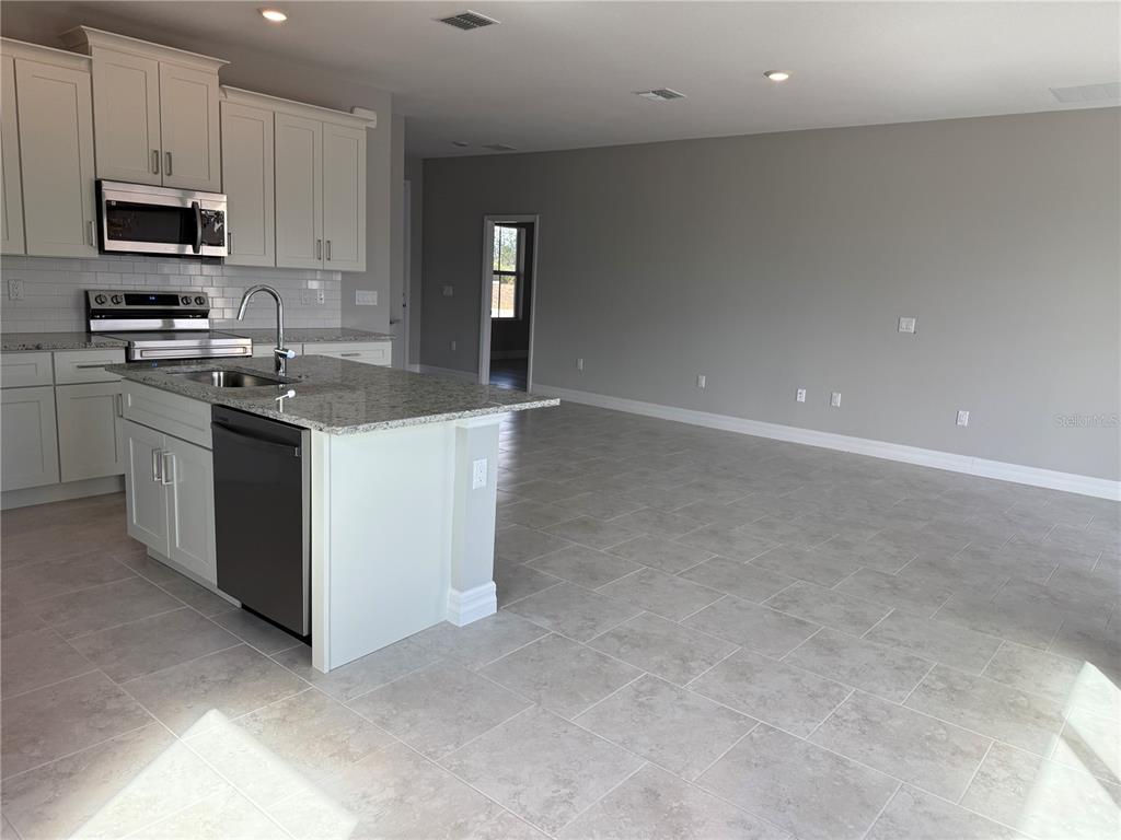 2268 Brewster Road North Port, FL 34288 - Photo 10 of 33 a kitchen with stainless steel appliances granite countertop a stove top oven a sink and a granite counter tops