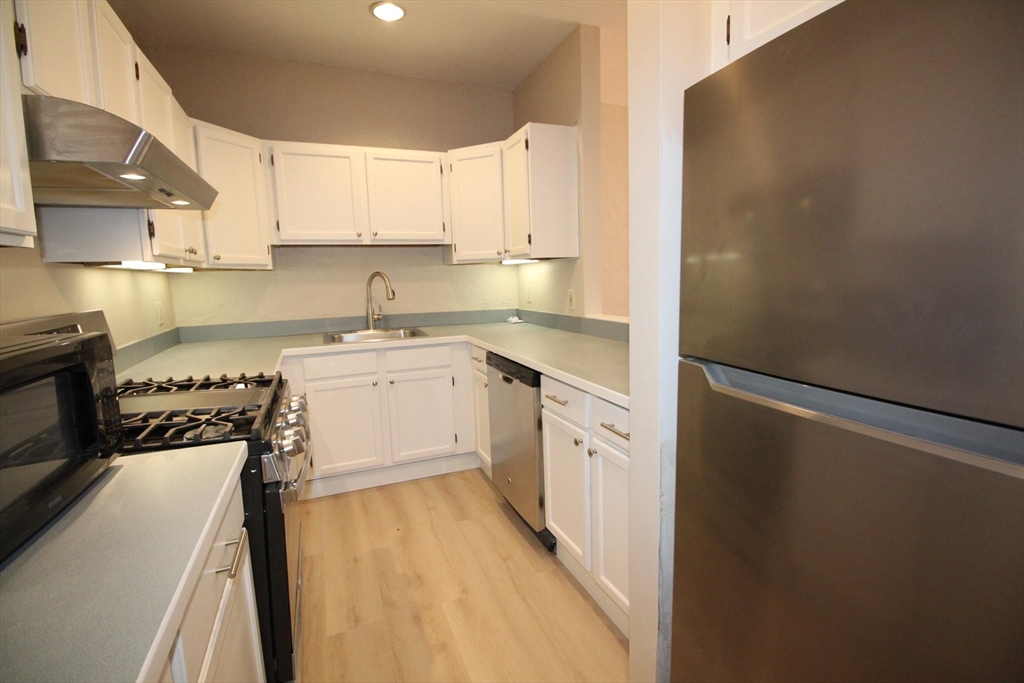 11 Worcester Street, Unit 2 Boston, MA 02118 - Photo 5 of 23 a kitchen with a sink a stove a refrigerator and white cabinets