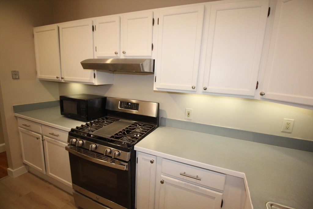 11 Worcester Street, Unit 2 Boston, MA 02118 - Photo 6 of 23 a kitchen with granite countertop a stove and white cabinets
