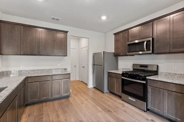 a kitchen with stainless steel appliances wooden cabinets and a stove top oven