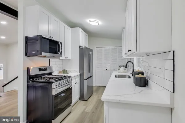 a kitchen with kitchen island a sink appliances and cabinets