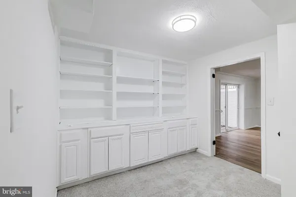 an empty room with windows and cabinet