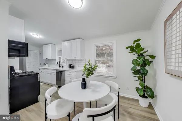 a dining room with furniture potted plants and wooden floor
