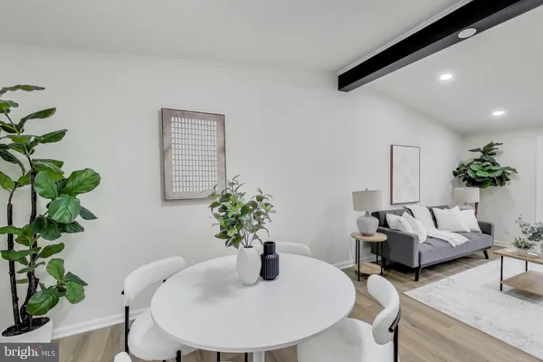 a dining room with furniture and a potted plant
