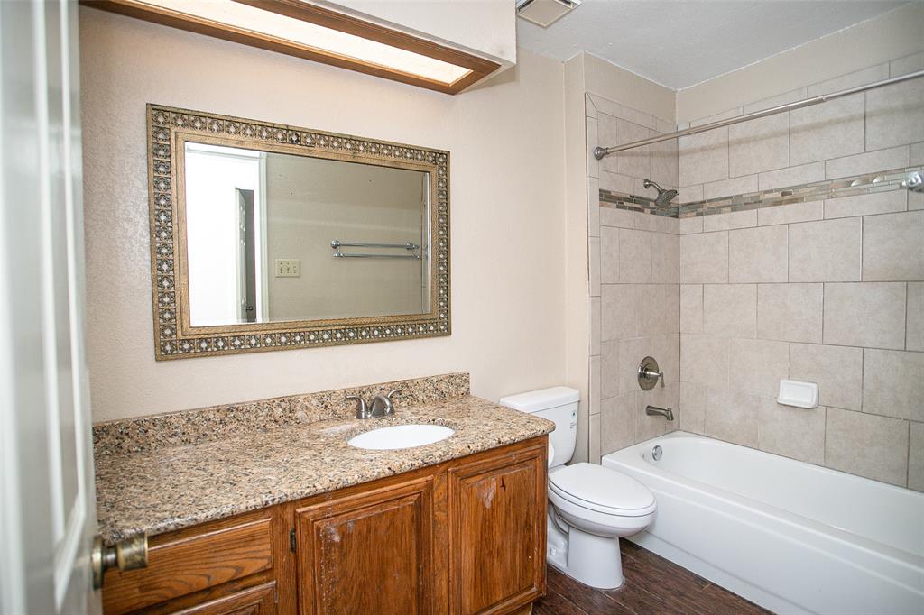 2019 West Nathan Lowe Road Arlington, TX 76017 - Photo 13 of 21 Neutral-toned room featuring a single window with blinds, wood-finish flooring, white trim, and an overhead flush-mount light fixture
